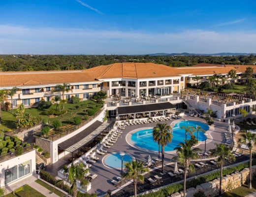 Aerial view of the Wyndham Grand Algarve showing the pool in front surrounded by sun loungers